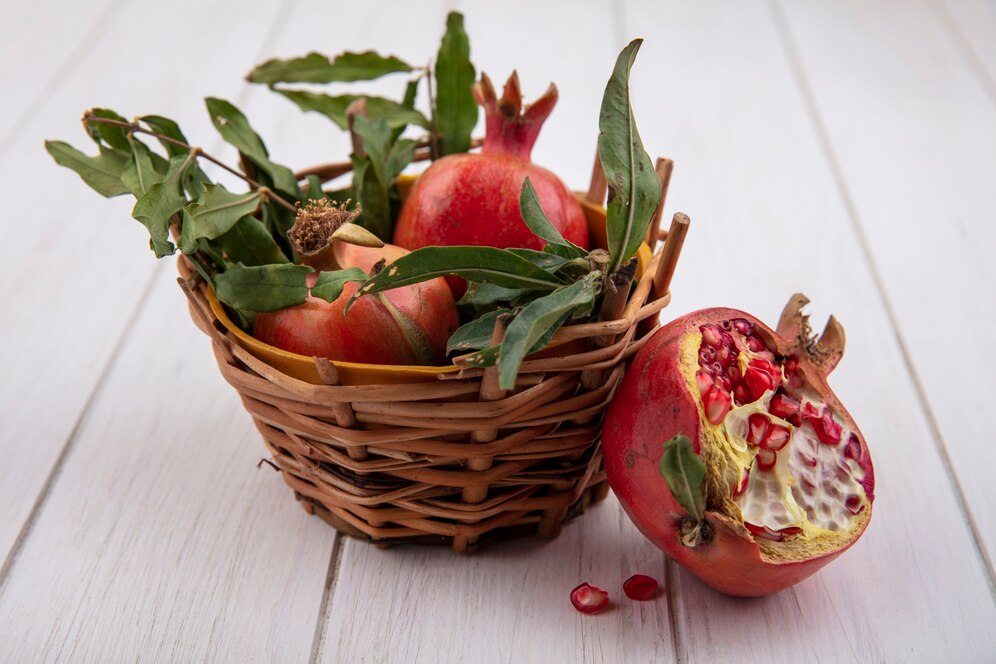 front-view-pomegranates-with-branches-leaves-basket-white-background_141793-49377